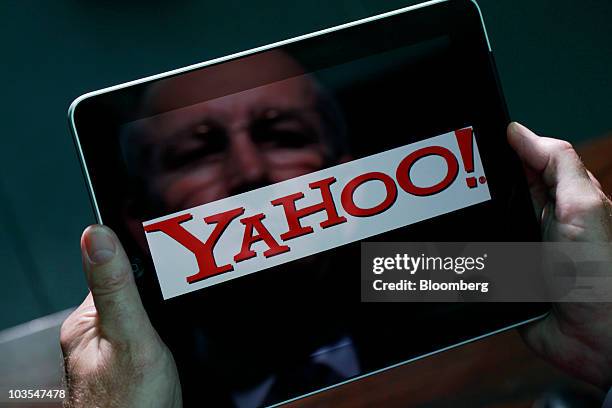 Businessman checks the Yahoo! Inc company logo on the screen of Apple Inc.'s Apple iPad in an arranged photograph in London, U.K., on Thursday,...