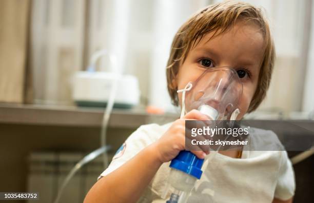 niño mediante nebulizador durante terapia de la inhalación. - nebulizador fotografías e imágenes de stock
