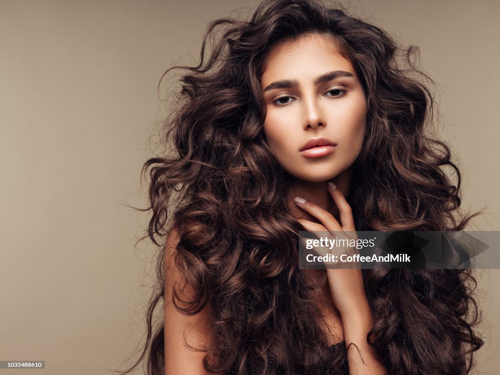 Beautiful girl with lush curly hairstyle