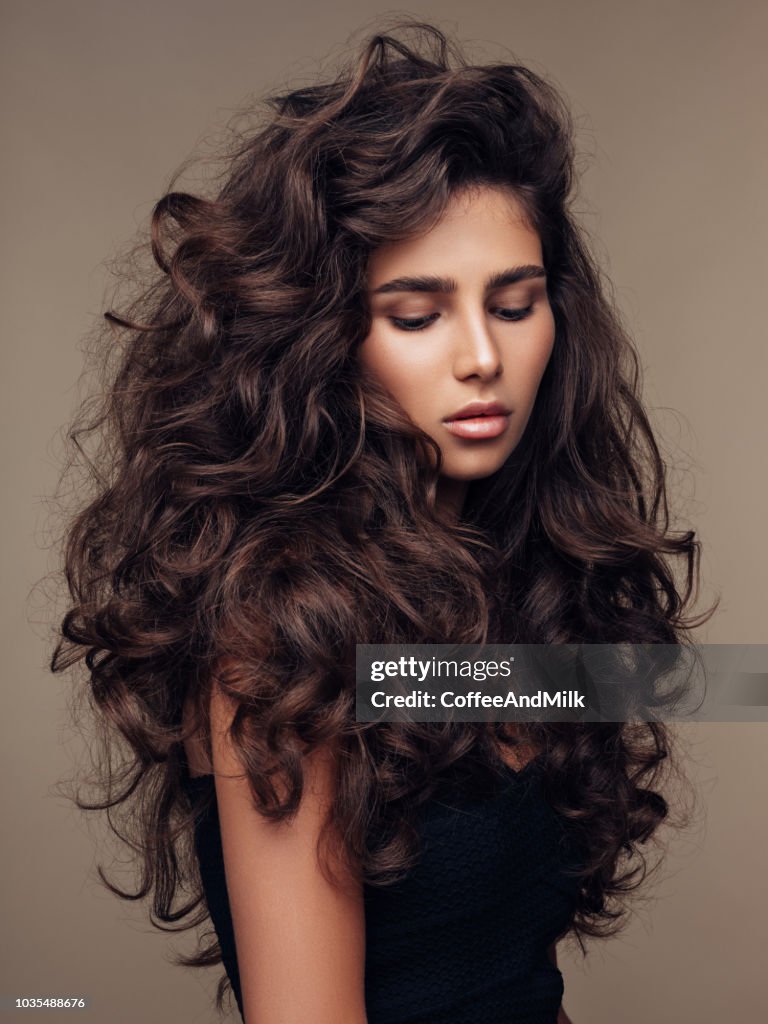 Beautiful Girl With Lush Curly Hairstyle High-Res Stock Photo - Getty Images