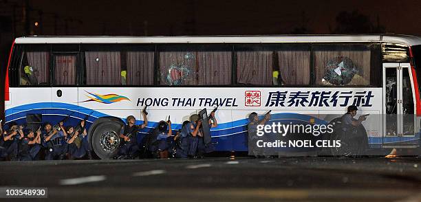 Philippine police take positions alongside the exterior of the bus as they start their assault in a bid to free 15 hostages from Hong Kong who remain...
