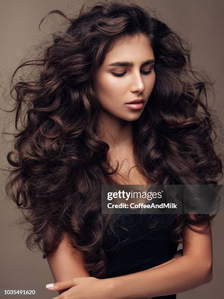 beautiful girl with lush curly hairstyle - shiny wavy hair stock pictures, royalty-free photos & images