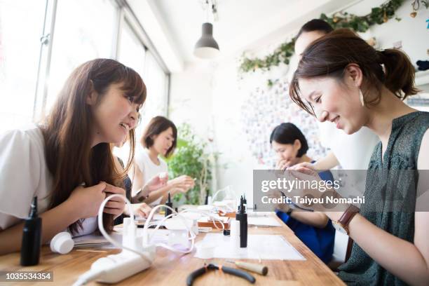 a woman who participates in a workshop and makes accessories - woman smiling facing down stock pictures, royalty-free photos & images