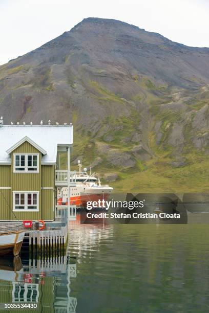 big ship reflected in fjord water at dalvik harbour iceland - iceland harbour stock-fotos und bilder