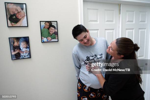 Thomas Beatie, a transgender male, his wife Nancy hug near family pictures as his contractions grow, leading to the birth to son Jensen James Beatie...