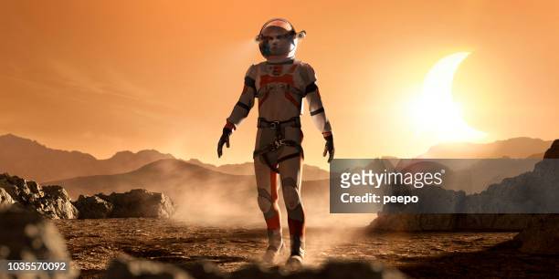 mars astronaut voet door rotsachtige martiaanse landschap tijdens zonsverduistering - ruimtemissie stockfoto's en -beelden