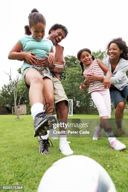 family playing football in park - peter parks stock pictures, royalty-free photos & images