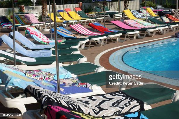 towels on sunbeds around swimming pool - shy bildbanksfoton och bilder