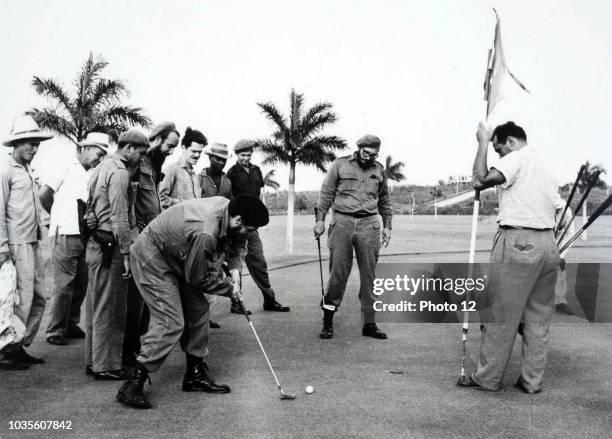 Che Guevara putts as Fidel Castro watches, during 1962 golf game at Havana's Colinas de Villarreal golf course, following the Cuban missile crisis.