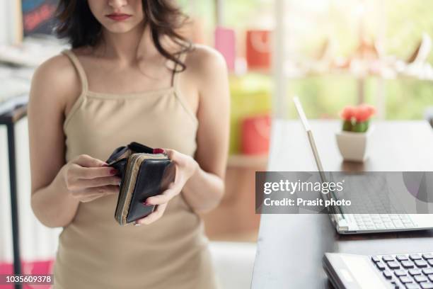 asian woman in clothes store unhappy when she know no money in her wallet. - lady wallet stock-fotos und bilder