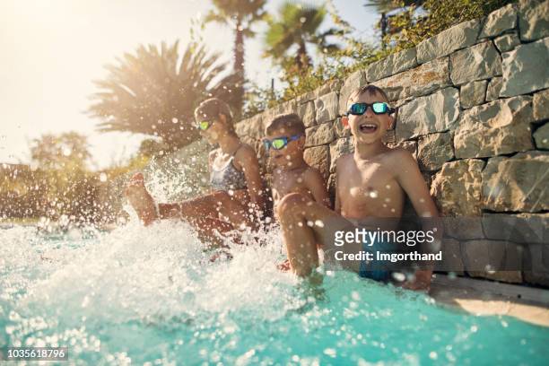 kids playing in swimming pool - family holidays hotel stock pictures, royalty-free photos & images
