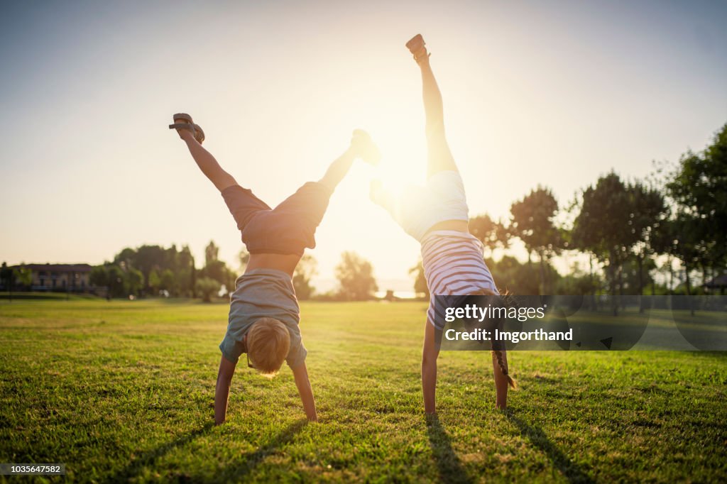 Broer en zus permanent op handen op gras