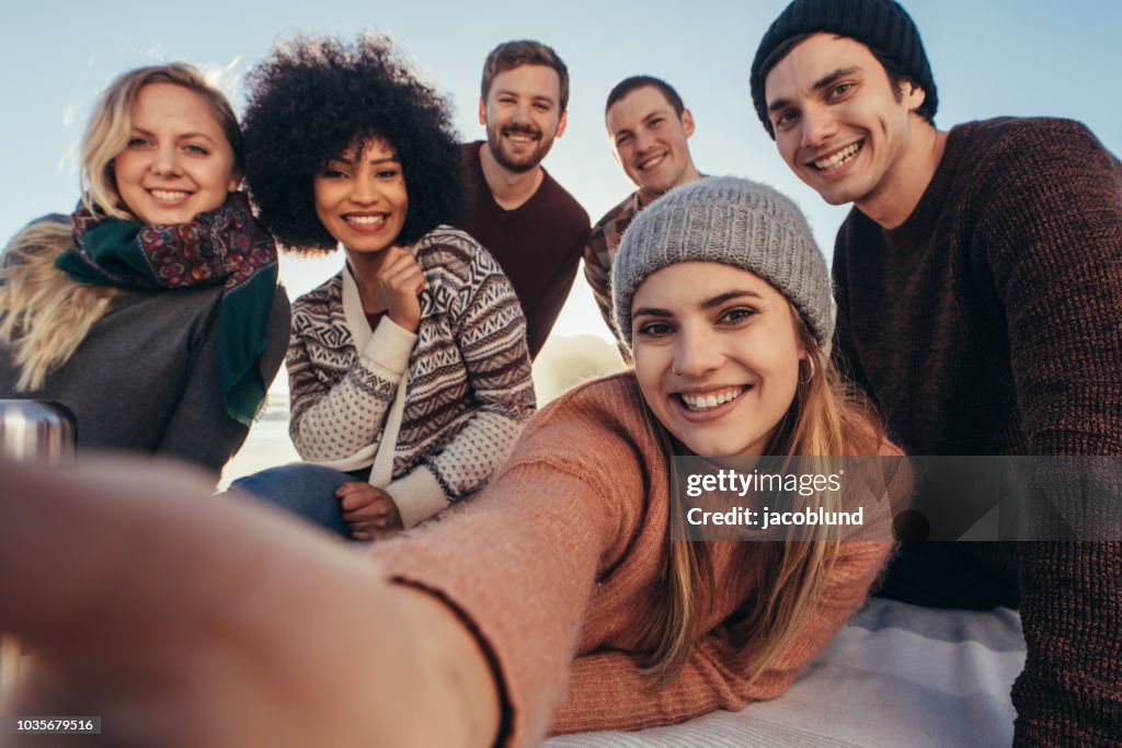 Friends taking selfie during beach party