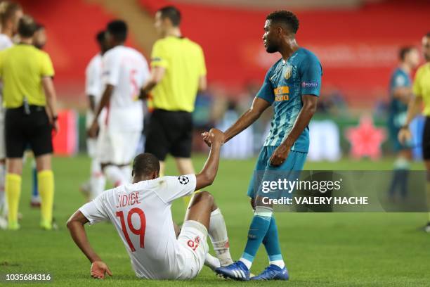 Atletico Madrid's French midfielder Thomas Lemar helps Monaco's French defender Djibril Sidibe to stand up at the end of the UEFA Champions League...