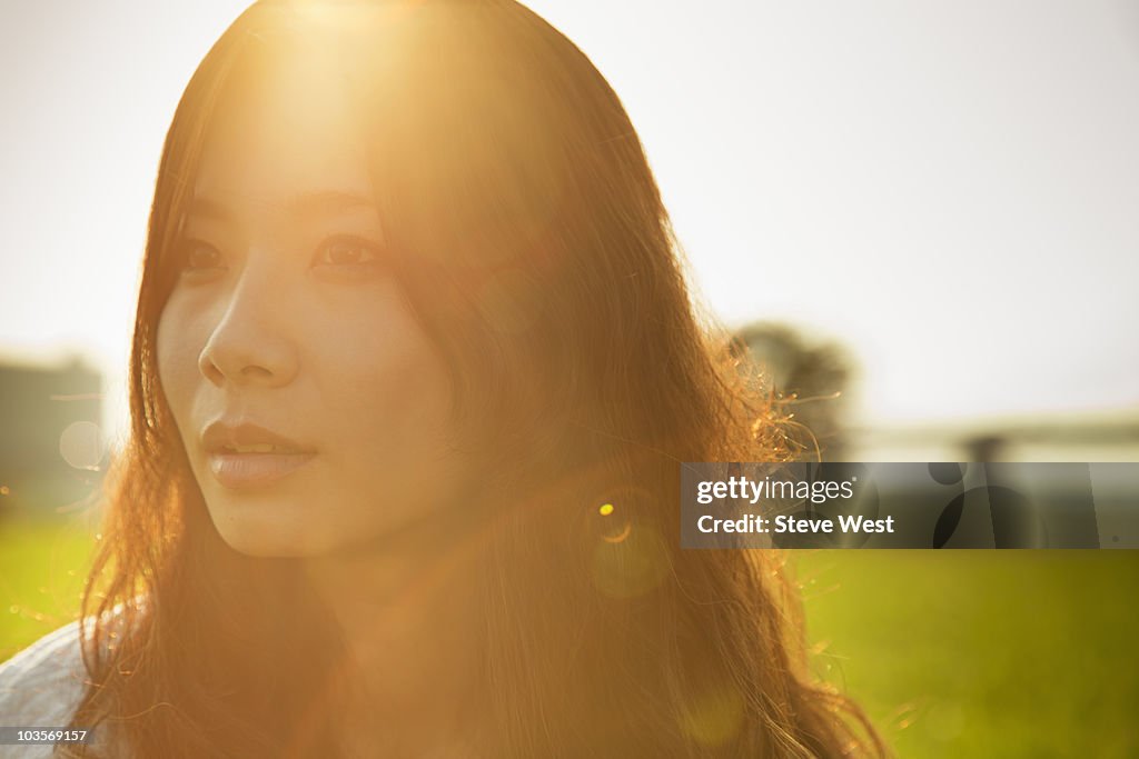 Portrait of young Asian woman outdoors at sunset