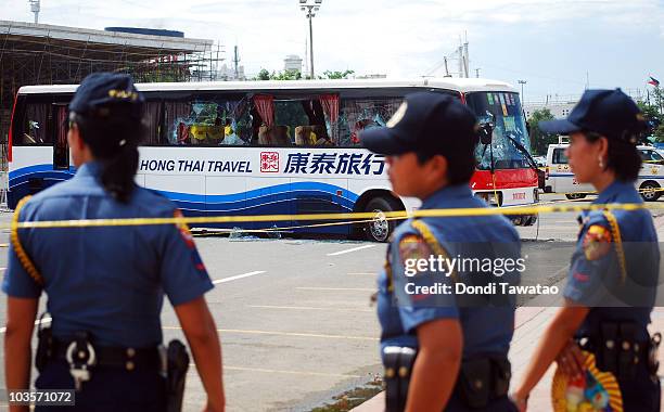 Philippine security officials cordon the perimeter of the bus after a hostage stand-off that resulted in the death of atleast 8 hostages and the...