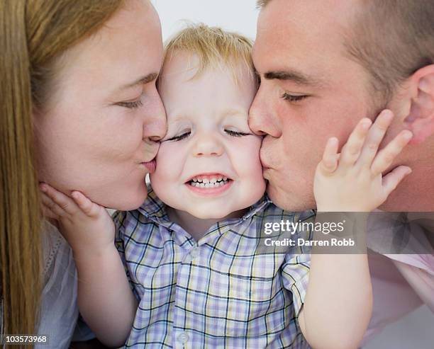 young couple kissing young boy - friends kissing cheeks stockfoto's en -beelden