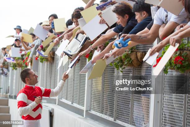 Jockey Mirco Demuro gives his autograph to Japanese racing fans after Sister Flag winning the Race 8 at Sapporo Racecourse on August 26, 2018 in...