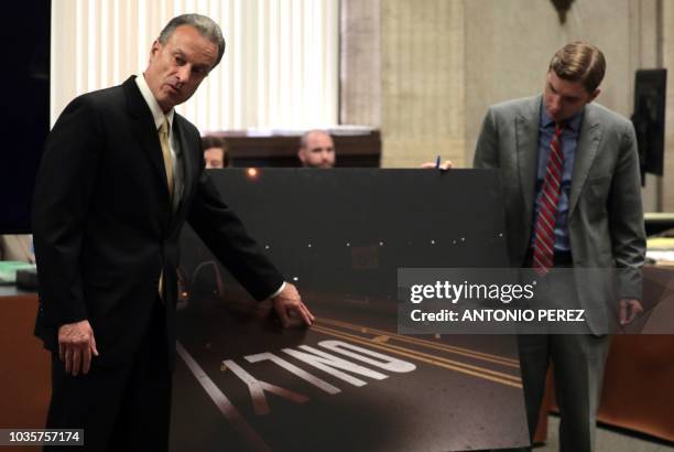 Anthony Wojcik gives testimony on measurements and evidence as prosecuting attorney Dan Weiler helps hold up a crime scene photo, during the trial...