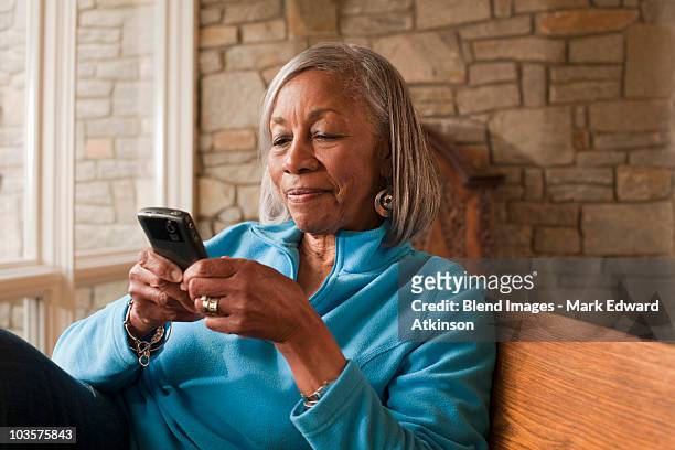black woman text messaging on cell phone - senior using phone stock pictures, royalty-free photos & images