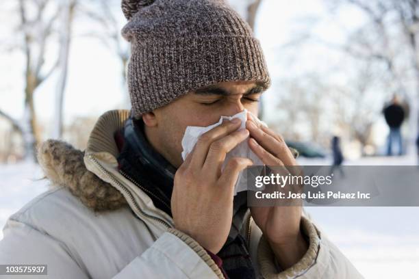 mixed race man blowing nose outdoors - hankerchief stock pictures, royalty-free photos & images