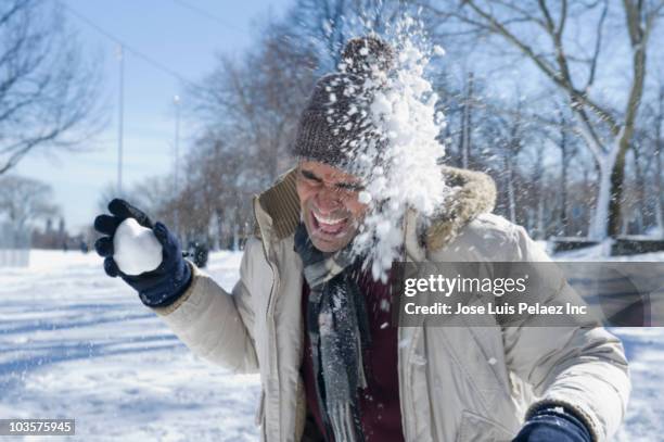 mixed race man having snowball fight - snowball stock pictures, royalty-free photos & images