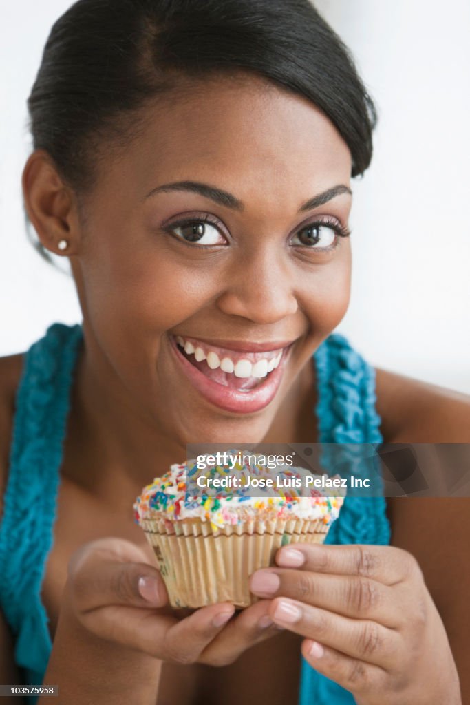 African American woman holding cupcake