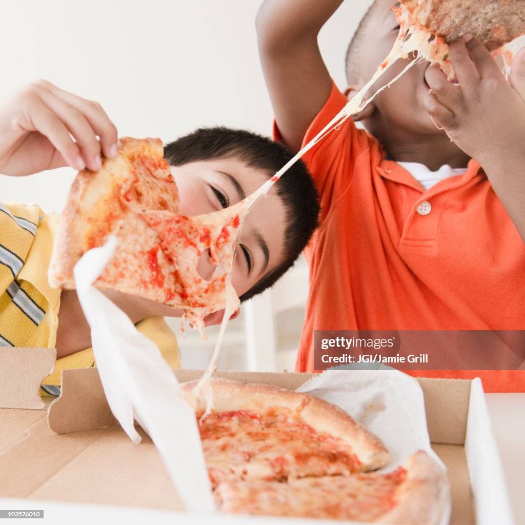 Boys eating pizza together