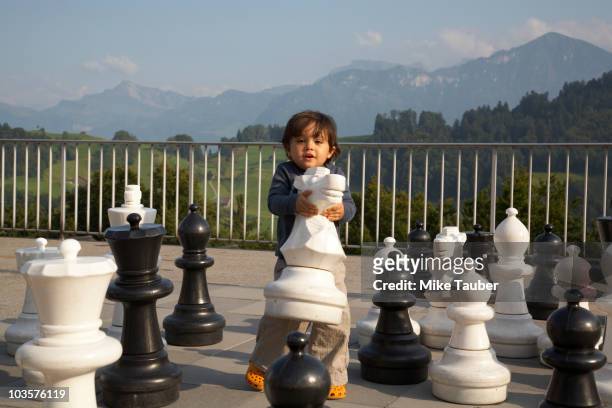 mixed race boy playing with large chess pieces - asian games day 3 stock-fotos und bilder
