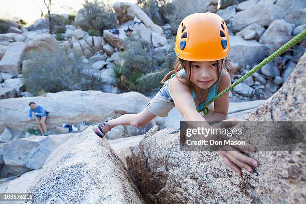 Mixed race girl rock climbing