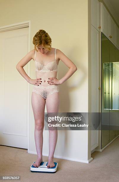 young woman standing on scales - girls in bras photos fotografías e imágenes de stock