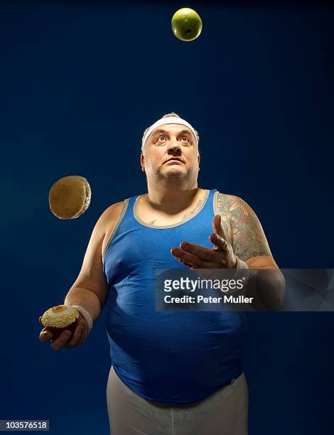 large sportsman juggling food - burger portrait photos et images de collection
