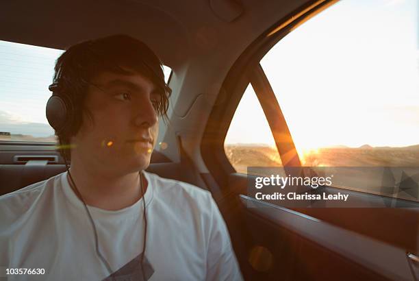 boy traveling in back seat of car - boy headphones stock-fotos und bilder