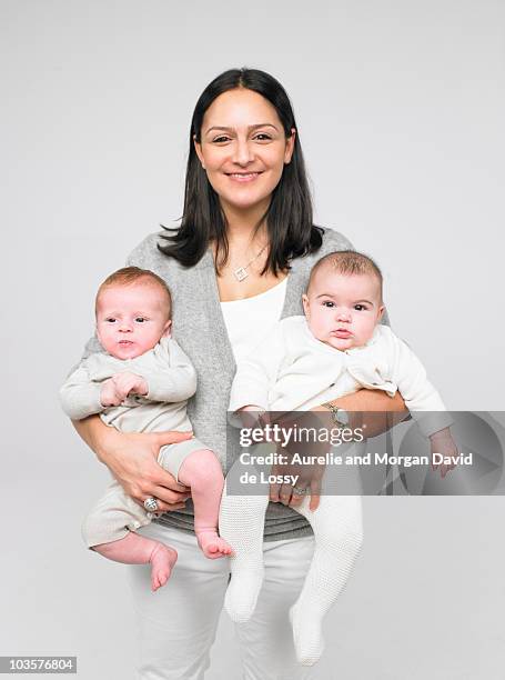 mother holding two babies - stolz freisteller stock-fotos und bilder