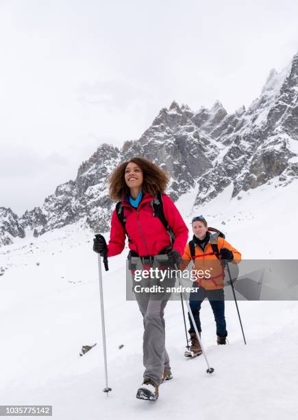 coppia felice che escursioni sulle montagne innevate - hiking pole foto e immagini stock