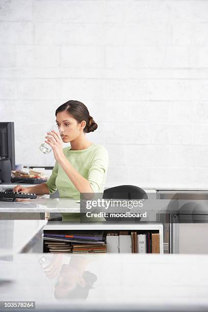 young woman in office, drinking water from glass - wasser trinken büro stock-fotos und bilder