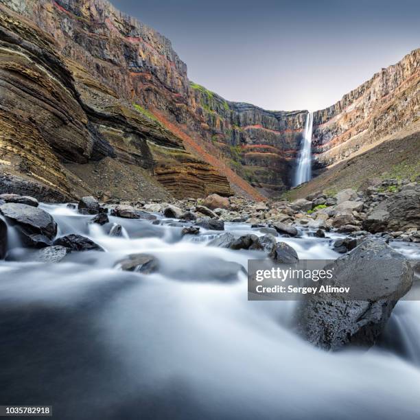 long exposed view of river and hengifoss waterfall in iceland - río del este fotografías e imágenes de stock