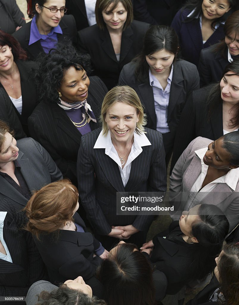 Group of business women looking at woman standing in middle, elevated view