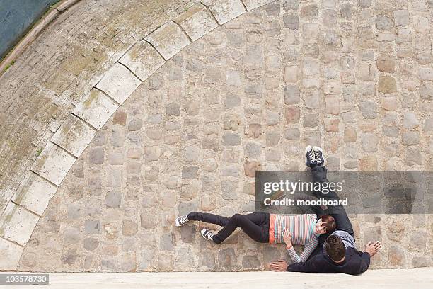 couple relaxing on cobble stones, view from above - pavement photos et images de collection
