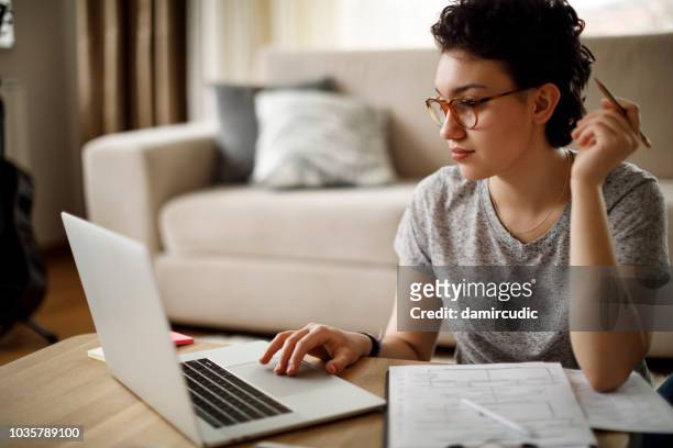 joven mujer trabajando en su casa  - plano documento fotografías e imágenes de stock