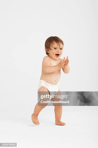 excited toddler taking first steps in white studio - clapping hands on white stock pictures, royalty-free photos & images