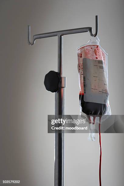 drip bag with blood on stand, against white background - blood bag stock-fotos und bilder