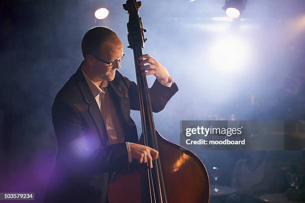 double bass player on stage, portrait - kontrabass stock-fotos und bilder