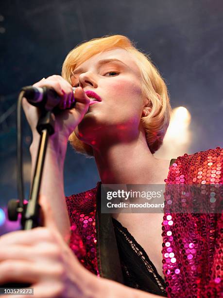 young woman singing in concert on stage, low angle view, close up - celebrities portrait stock pictures, royalty-free photos & images