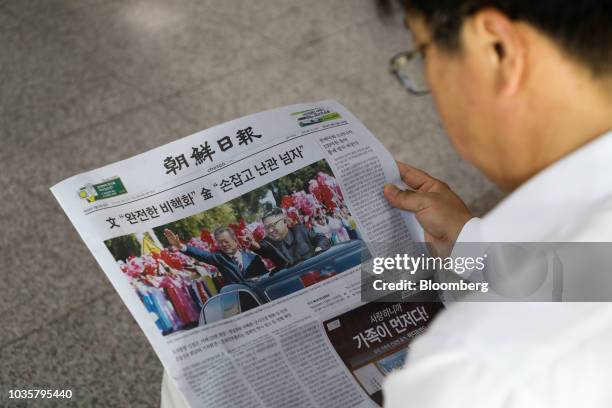 Man reads a copy of the Chosun Ilbo newspaper featuring a photograph of North Korean Leader Kim Jong Un and South Korean President Moon Jae-in on the...