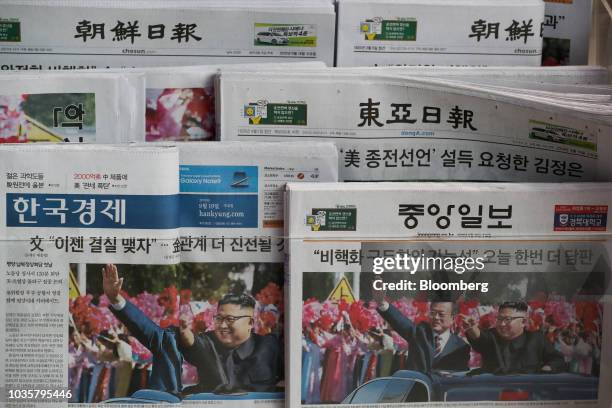 Newspapers featuring a photograph of North Korean Leader Kim Jong Un and South Korean President Moon Jae-in on the front page are displayed for sale...