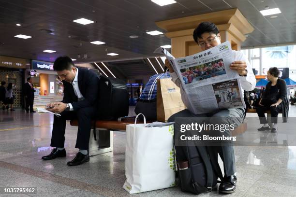Man reads a copy of the Chosun Ilbo newspaper featuring a photograph of North Korean Leader Kim Jong Un and South Korean President Moon Jae-in on the...