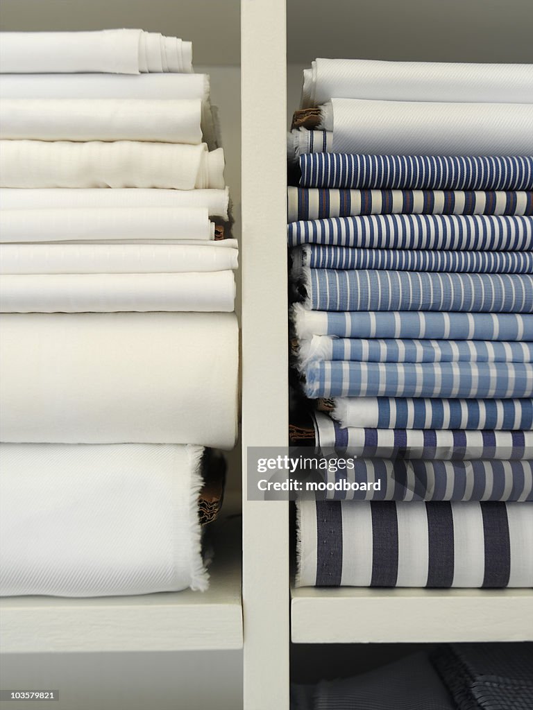 Two piles of cotton towels on shelf
