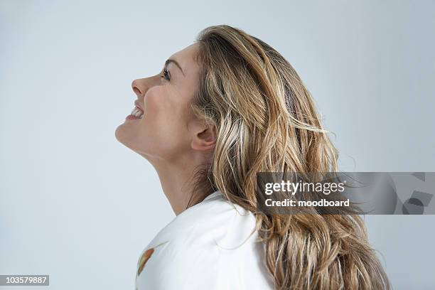 profile of young woman smiling - woman looking up sideview stock-fotos und bilder