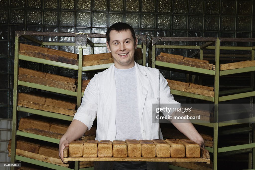 Baker Carrying Loaves of Fresh Bread